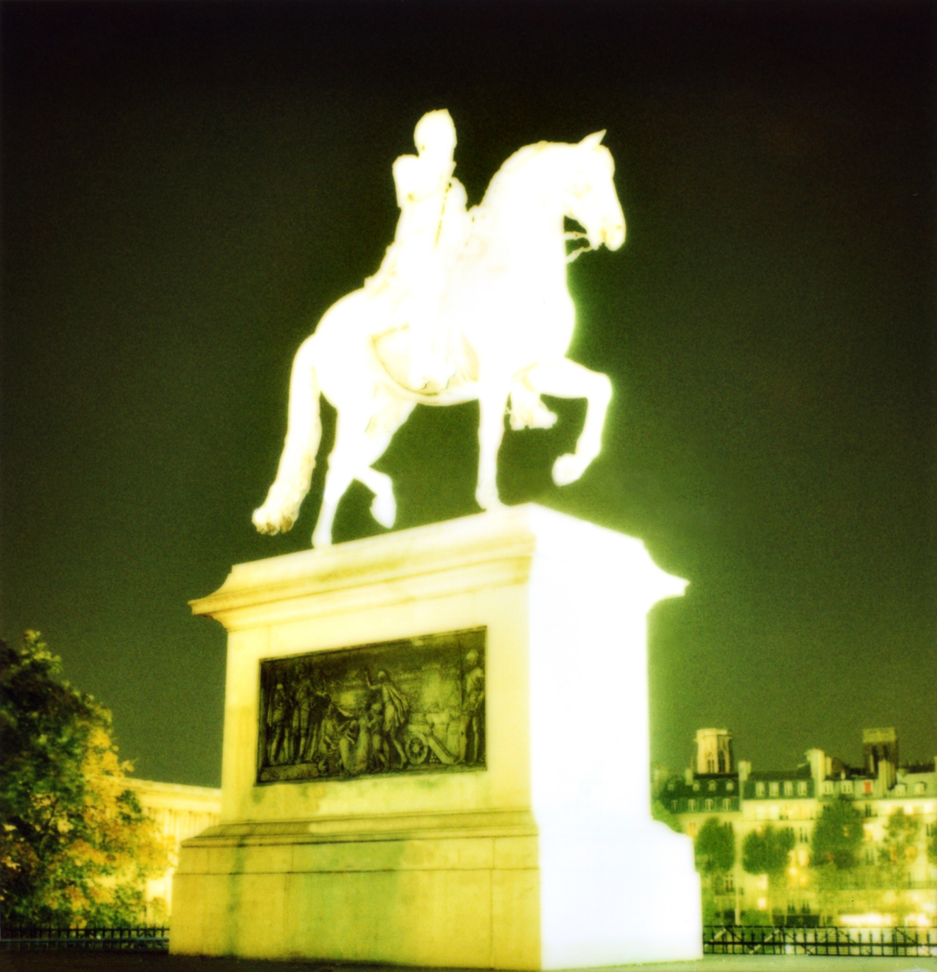 Photographie de la statue d'Henri IV sur un pont de Paris, surexposée pour apparaître telle une lumière dans la nuit.